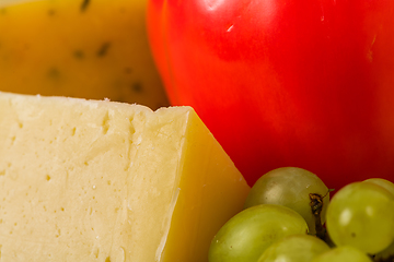 Image showing Bosnian traditional cheese served on a wooden container with peppers, parade and onions isolated on a white background