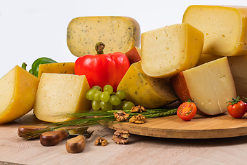 Image showing Bosnian traditional cheese served on a wooden container with peppers, parade and onions isolated on a white background