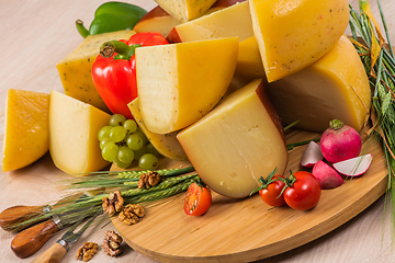 Image showing Bosnian traditional cheese served on a wooden container with peppers, parade and onions isolated on a white background