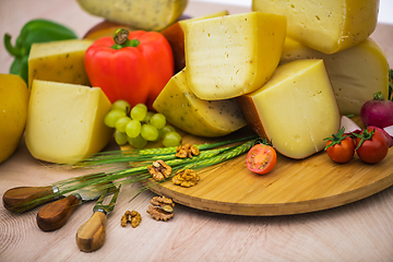 Image showing Bosnian traditional cheese served on a wooden container with peppers, parade and onions isolated on a white background