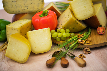 Image showing Bosnian traditional cheese served on a wooden container with peppers, parade and onions isolated on a white background