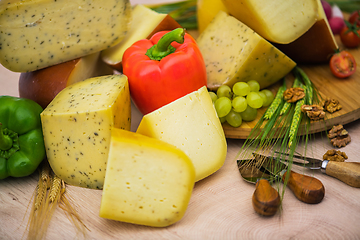 Image showing Bosnian traditional cheese served on a wooden container with peppers, parade and onions isolated on a white background