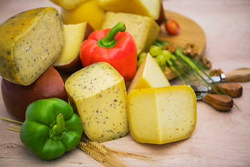 Image showing Bosnian traditional cheese served on a wooden container with peppers, parade and onions isolated on a white background