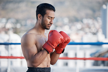 Image showing Fitness, boxer praying or man fighting in a ring on rooftop in city for combat training or meditation. Eyes closed, Muay Thai athlete or Asian mma fighter ready for workout, exercise or match battle