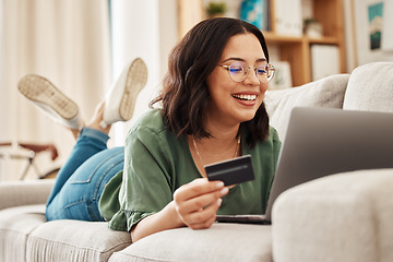 Image showing Relax, laptop and credit card, happy woman on couch in living room for internet banking in home for online shopping. Ecommerce payment, smile and cashback, girl on sofa with computer and website sale