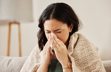 Image showing Nose, tissue and sick woman sneezing on a sofa with allergy, cold or flu in her home. Hay fever, allergy and female with viral infection, problem or health crisis in a living room with congestion