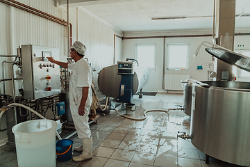 Image showing Cheese maker working in the modern industry on machines that are using for the machining of fresh cheese