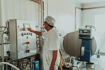 Image showing Cheese maker working in the modern industry on machines that are using for the machining of fresh cheese