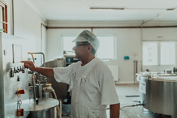 Image showing Cheese maker working in the modern industry on machines that are using for the machining of fresh cheese