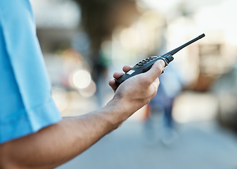 Image showing Hand, walkie talkie and a security guard or safety officer outdoor on a city road for communication. Closeup of person with a radio on urban street to report crime for investigation and surveillance