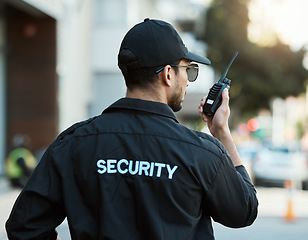 Image showing Radio, man and a security guard or safety officer outdoor on a city road for communication. Back of a person with a walkie talkie on urban street to report crime for investigation and surveillance