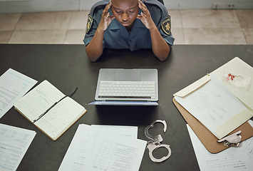 Image showing Police, woman and working with stress at desk with documents, paperwork or frustrated with headache from working on computer case, report. Security, officer and tired from work in office or station