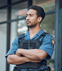 Image showing Security, police and man with crossed arms in city for working, inspection and supervision on patrol. Uniform, law enforcement and male person in urban town for safety, crime and protection service