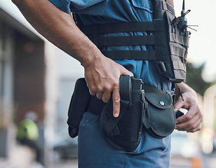 Image showing Security, police and hands of man with gun in city for shift, inspection and supervision on patrol. Weapon, law enforcement and closeup of male person in town for safety, crime and protection service