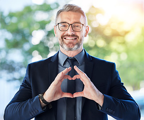 Image showing Face, business man and ceo with heart hands outdoor for trust, care and happy. Portrait, mature with love sign, smile for kindness or empathy, charity or gratitude, romance emoji or support