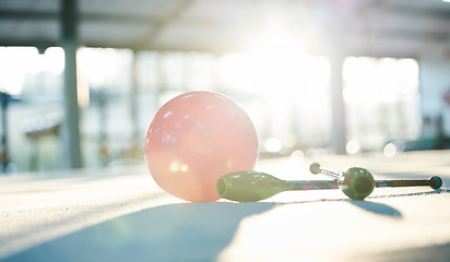 Image showing Gymnastics, aerobics and ball on floor in gym for rhythmic movement, training and exercise in studio. Creative performance, fitness and closeup of equipment for competition, sports and dance club