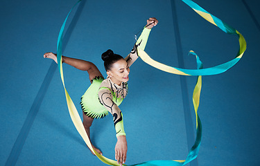 Image showing Rhythmic gymnastics, woman in gym and ribbon with balance, action with performance and fitness. Competition, athlete and female gymnast, creativity and art with dancing routine and energy at arena