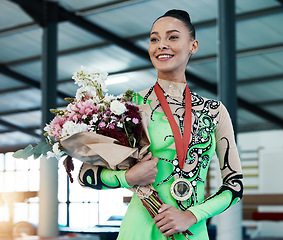 Image showing Woman, gymnastics and winner, medal and flower bouquet, happy with celebration and winning competition. Prize, reward and bonus, female champion on podium with gymnast and athlete smile with gift