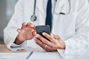 Image showing Smartphone, hands and doctor typing at table in hospital for research, telehealth or healthcare. Phone, medical professional or surgeon, expert or person on wellness app, email or online consultation