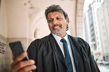 Image showing Phone, app and a senior man judge at court, outdoor in the city during recess from a legal case or trial. Smile, mobile and communication with a confident magistrate in an urban town to practice law