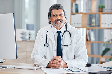 Image showing Doctor, portrait and man in healthcare office for consultation, support and services or advice at table. Happy face of medical worker or senior person with health insurance in clinic or hospital