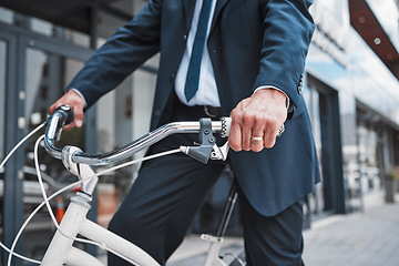 Image showing Hands, bicycle and businessman cycling in the city or riding for eco friendly travel, transport or commute to office, building or work. Man, driving and bike for carbon neutral footprint in town