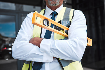 Image showing Man, arms crossed and architect has level, construction and confident in city, maintenance and project management. Urban infrastructure, architecture and male contractor with tools and professional