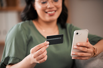 Image showing Smile, woman and a credit card and phone for online shopping, banking app or ecommerce on the sofa. Happy, house and closeup of a girl with a mobile for retail, payment or online finance on the couch