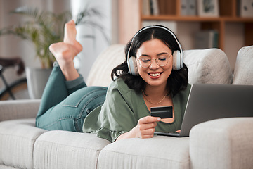 Image showing Woman, credit card and headphones on computer online shopping, e learning and fintech payment on sofa. Student or person relax with music subscription, banking services and home education on laptop