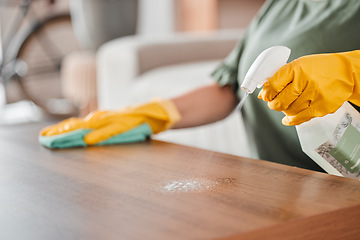 Image showing Hands, cleaning and spray on a wooden table for hygiene, disinfection or to sanitize a surface in a home. Gloves, bacteria and product with a woman cleaner in the living room for housework or chores