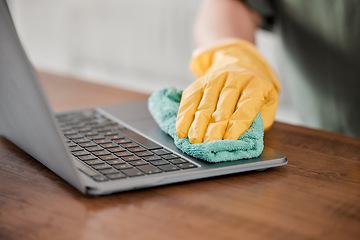 Image showing Person, hands and cleaning laptop for disinfection, bacteria or germ removal on wooden table at home. Closeup of housekeeper, cleaner or maid wiping computer in sanitizing, hygiene or clean equipment