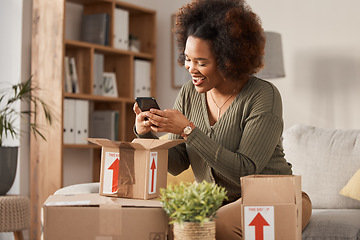 Image showing Boxes, phone and woman unboxing for online shopping, courier service and product review on social media. Cardboard package, e commerce and happy african person or influencer on mobile at home on sofa