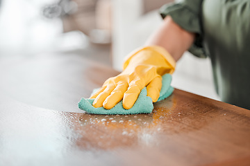 Image showing Hands, cleaning and bacteria on a wooden table for hygiene, disinfection or to sanitize a surface in a home. Gloves, spray and product with a woman cleaner in the living room for housework or chores