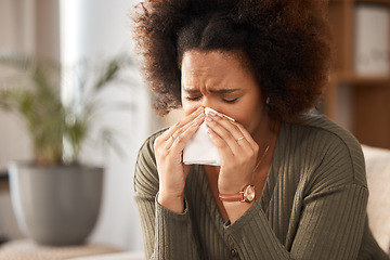 Image showing Sick woman, blowing nose and tissue with flu, illness or infection disease in living room at home. Sad, frustrated or ill female person with allergy, sinus or fever sneezing in living room at house