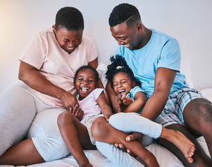 Image showing Happy, laugh and black family on a bed with games, tickle and bonding in a home on the weekend. Love, playing and children with parents in a bedroom, playful and having fun in the morning a house