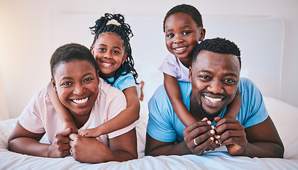 Image showing Happy, black family and portrait in a bed with smile, care and comfort on the weekend in their home. Face, love and children with parents in bedroom playing, hug and relax in the morning together