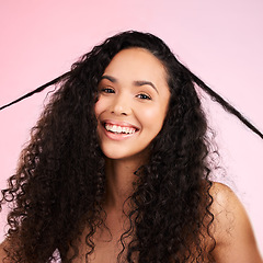 Image showing Face, woman and curly hair pull for beauty in studio isolated on a pink background. Portrait, natural cosmetics and hairstyle of happy model in salon treatment for growth, wellness and aesthetic