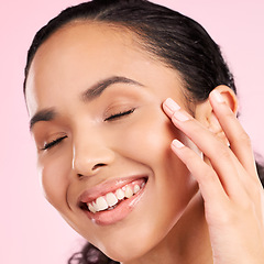 Image showing Beauty, skin cream and face of a woman in studio for cosmetics, dermatology and glow. Headshot, moisturizer and natural skincare of a young female aesthetic model on a pink background with a smile