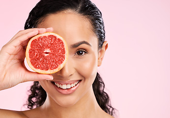 Image showing Face, skincare and happy woman with grapefruit in studio isolated on a pink background mockup space. Portrait, natural cosmetic or model with fruit, food or nutrition, healthy vegan diet or vitamin c