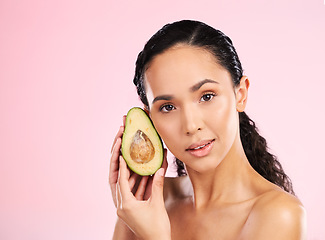 Image showing Face, skincare and serious woman with avocado in studio isolated on pink background mockup space. Portrait, natural cosmetic and model with fruit, food or nutrition for diet, vegan health or omega 3