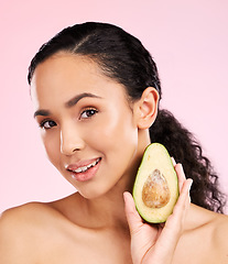 Image showing Face, skincare and woman with avocado in studio isolated on pink background. Portrait, natural cosmetic and model with fruit, food or nutrition for diet, vegan health or omega 3 benefits for wellness