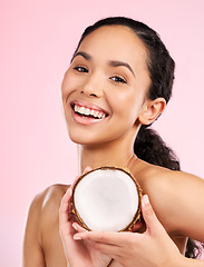 Image showing Woman face, coconut fruit and skincare, natural beauty or vegan cream on pink, studio background. Portrait of african person with healthy product for dermatology, skin care cosmetics and oil benefits