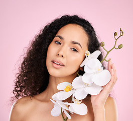 Image showing Face, orchid and skincare of woman for beauty in studio isolated on a pink background. Portrait, flowers and model with plant, floral cosmetic or natural organic treatment for healthy skin aesthetic