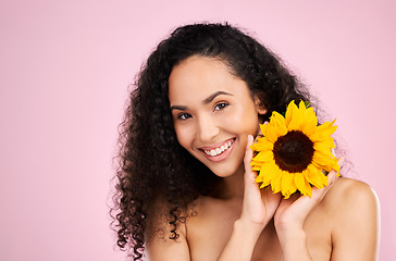 Image showing Face, skincare and beauty of woman with sunflower in studio isolated on a pink background mockup. Portrait, smile and natural model with flower, floral cosmetics or organic treatment for healthy skin