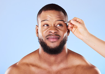 Image showing Beauty, tweezers and young man in a studio for grooming his eyebrows for face epilation. Health, hygiene and male model with facial hair removal treatment for self care isolated by a blue background.