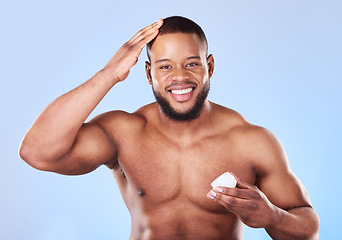 Image showing Beauty, portrait and a black man with cream for hair care, shine and moisture on a blue background. Happy, wellness and an African person or model with gel for growth isolated on a studio backdrop