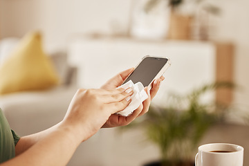 Image showing Closeup of a woman cleaning her phone with paper to prevent germs, dirt or dust bacteria at home. Hygiene, technology and female person wipe her cellphone to sanitize her screen in the living room.