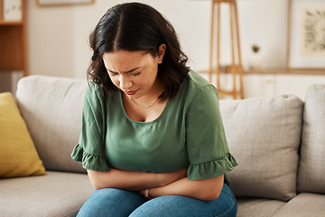 Image showing Stress, stomach pain and woman on a sofa with menstruation, gas or constipation, pms or nausea at home. Gut health, anxiety and lady with tummy ache in living room from ibs, bloated or endometriosis