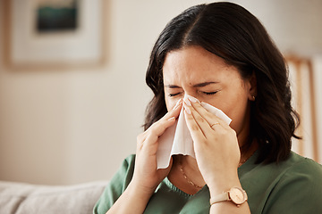 Image showing Tissue, blowing nose and woman in a living room with flu, cold and hay fever, crisis or viral infection in her home. Sneezing, allergies and person with health risk in a lounge or coughing illness