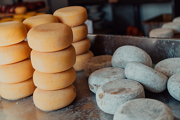 Image showing A large storehouse of manufactured cheese standing on the shelves ready to be transported to markets